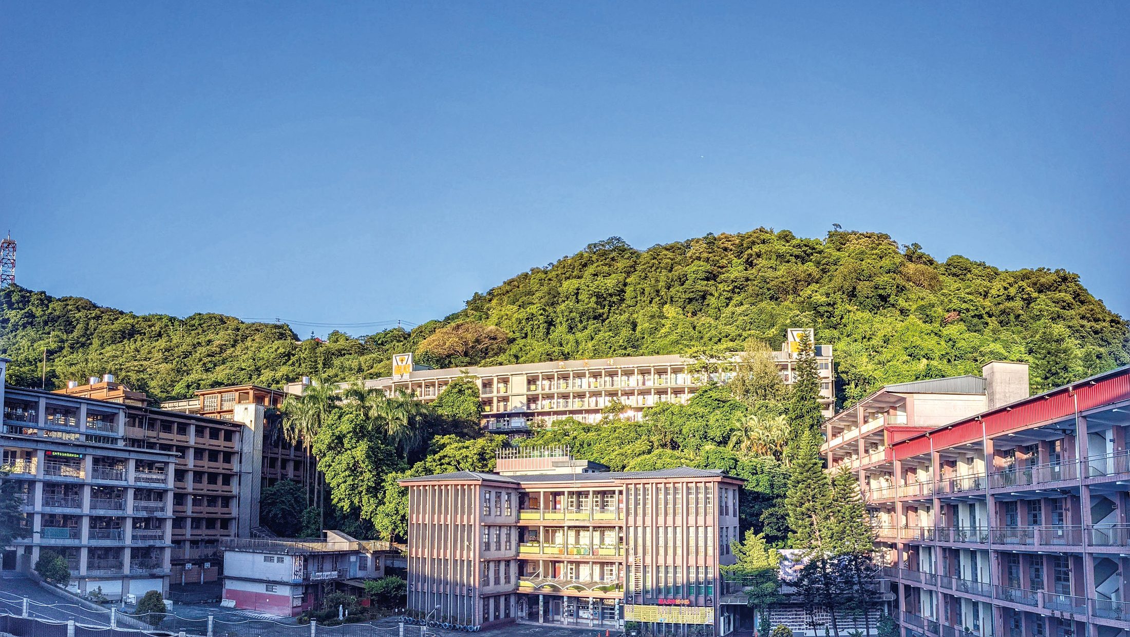 Sacred Heart campus buildings surrounded by the green hills of Keelung