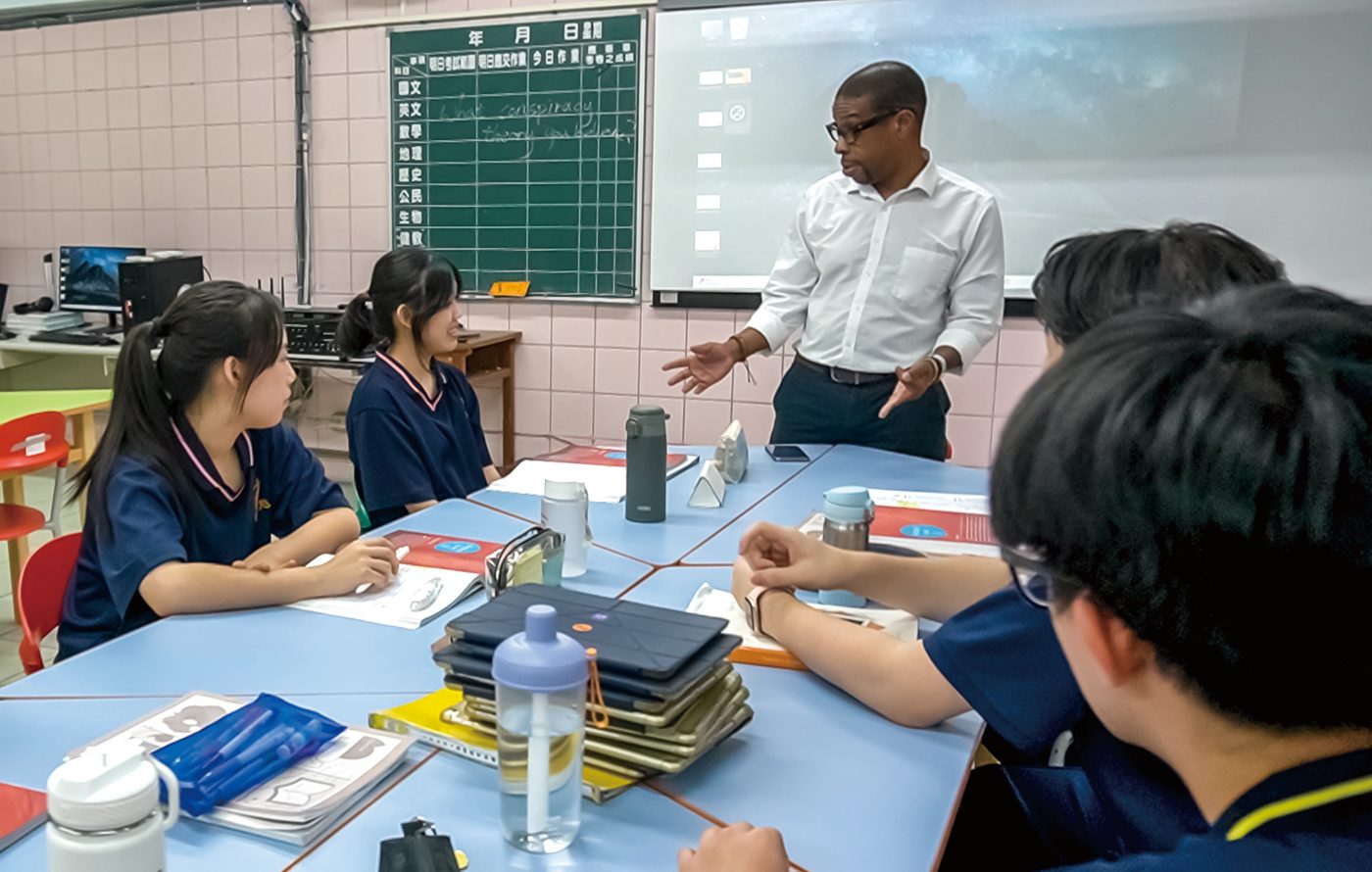 An English teacher and students in a small-group conversation